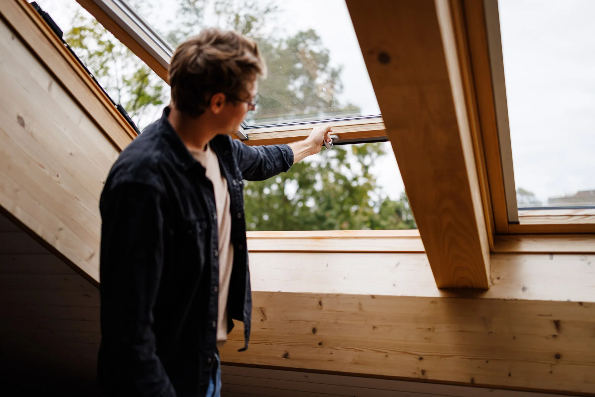 Ein Mann schliesst sein Dachfenster