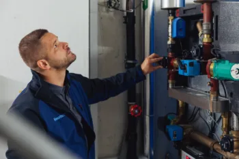 Haustechplus-Mitarbeiter prüft Heizungsleitungen