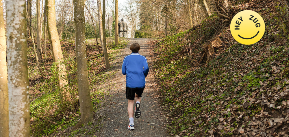Ein Jogger rennt auf einem Kiesweg im Wald.