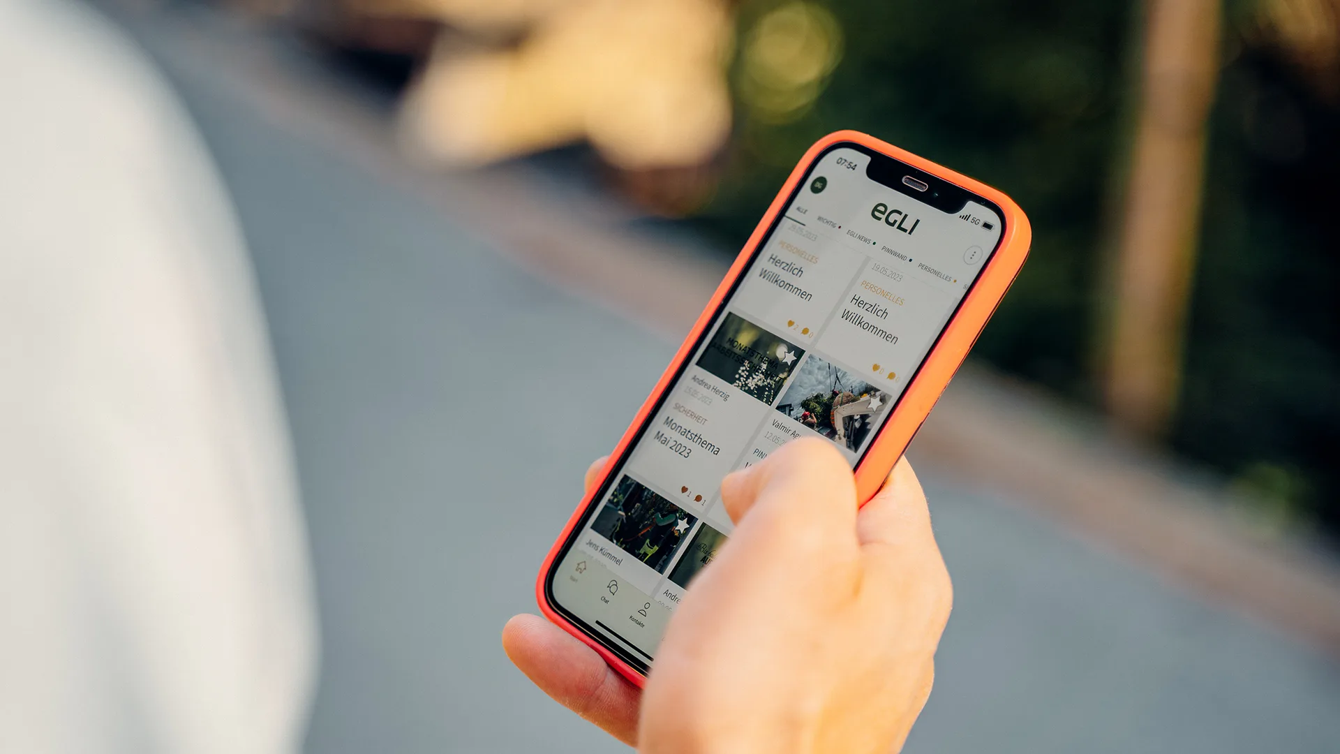 Hand haelt ein Smartphone, auf dem die Mitarbeitenden-App von Egli Gartenbau geöffnet ist