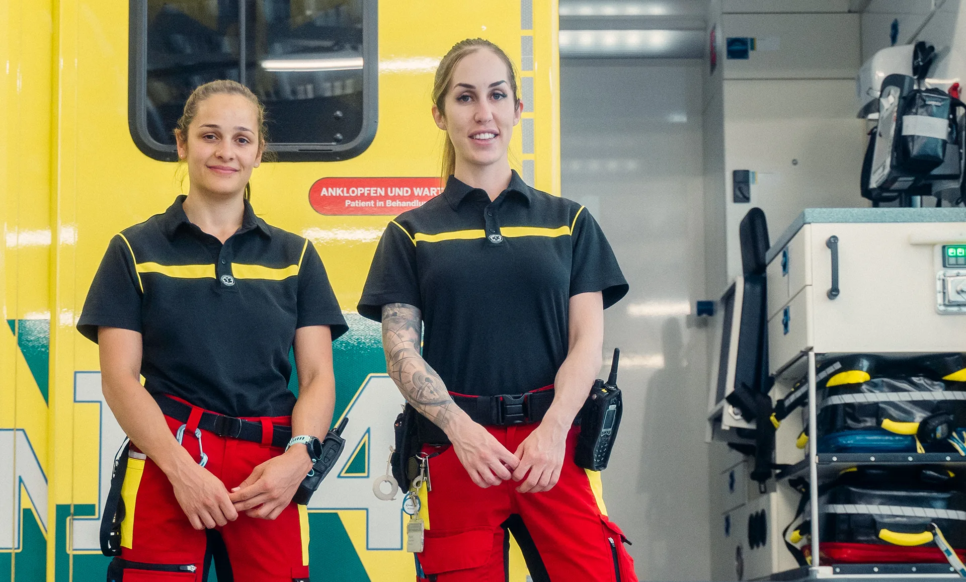 Zwei Mitarbeiterinnen des Rettungsdienst Winterthur stehen vor einem geöffneten Rettungswagen und blicken in die Kamera.