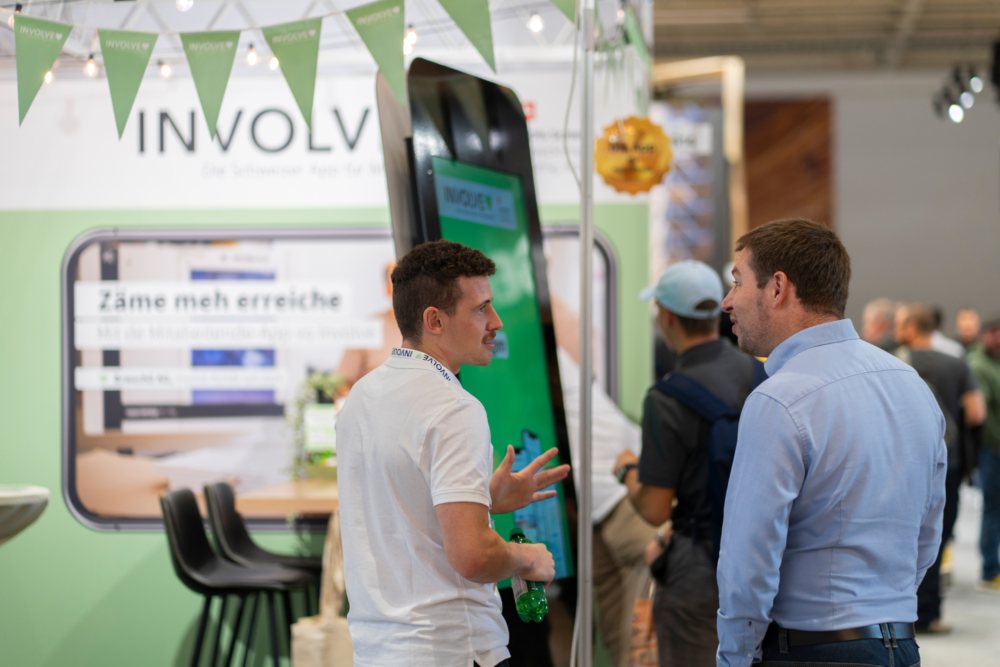 Roman Elmiger, Gebietsverkaufsleiter Ost, mit einem Messebesucher im Gespräch