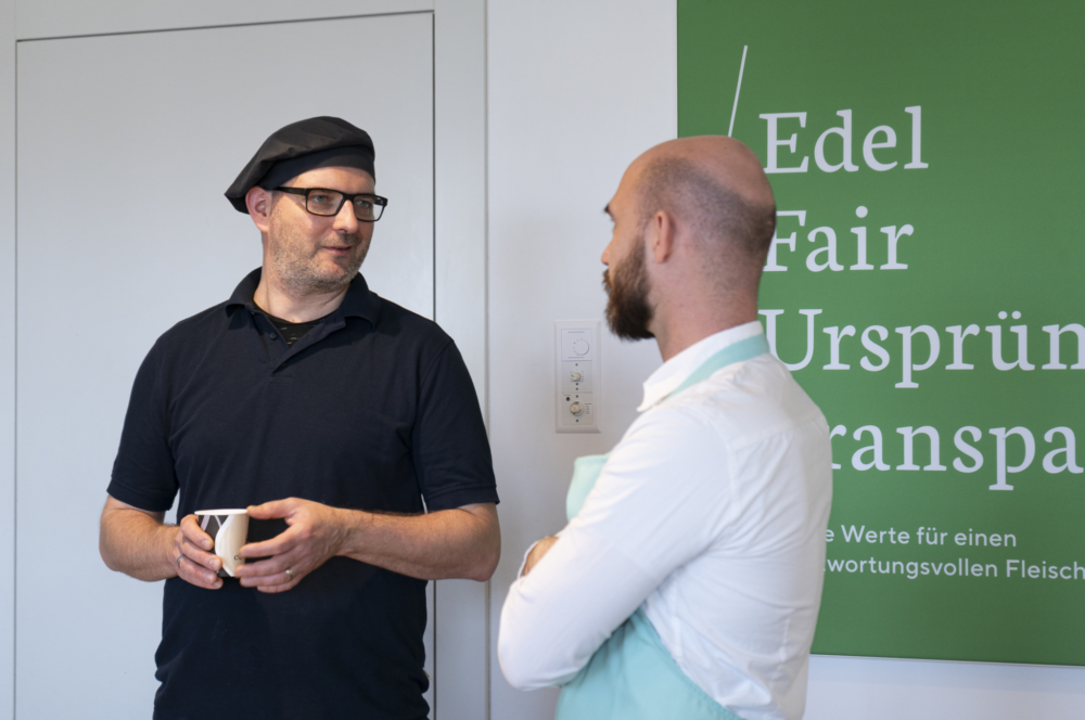 Ein Involve-Mitarbeitender und ein Mitarbeitender der Ueli Hof AG im Gespräch am Sockenevent 2025.