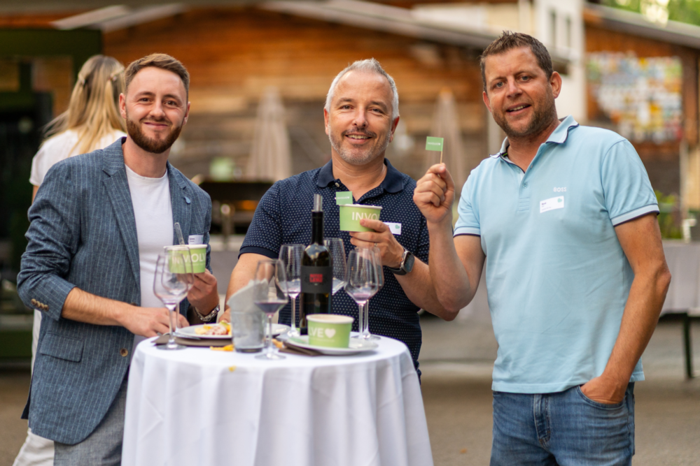 Drei Involve-Kunden bei der Involve Night 2025 im Burgrain Alberswil. Sie stehen um einen Stehtisch herum und lachen in die Kamera.