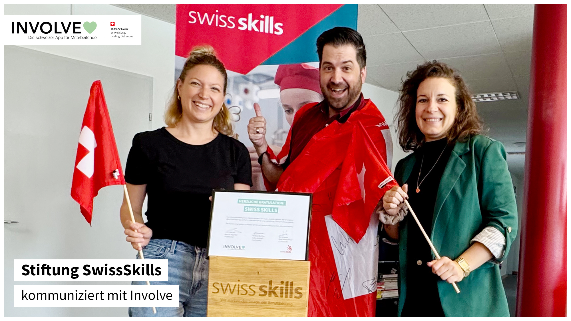 Marcos Albarrán, Projektleiter Involve AG, mit zwei Mitarbeiterinnen der Stiftung SwissSkills. In der Mitte ist das Zertifikat in einem Bilderrahmen zu sehen.