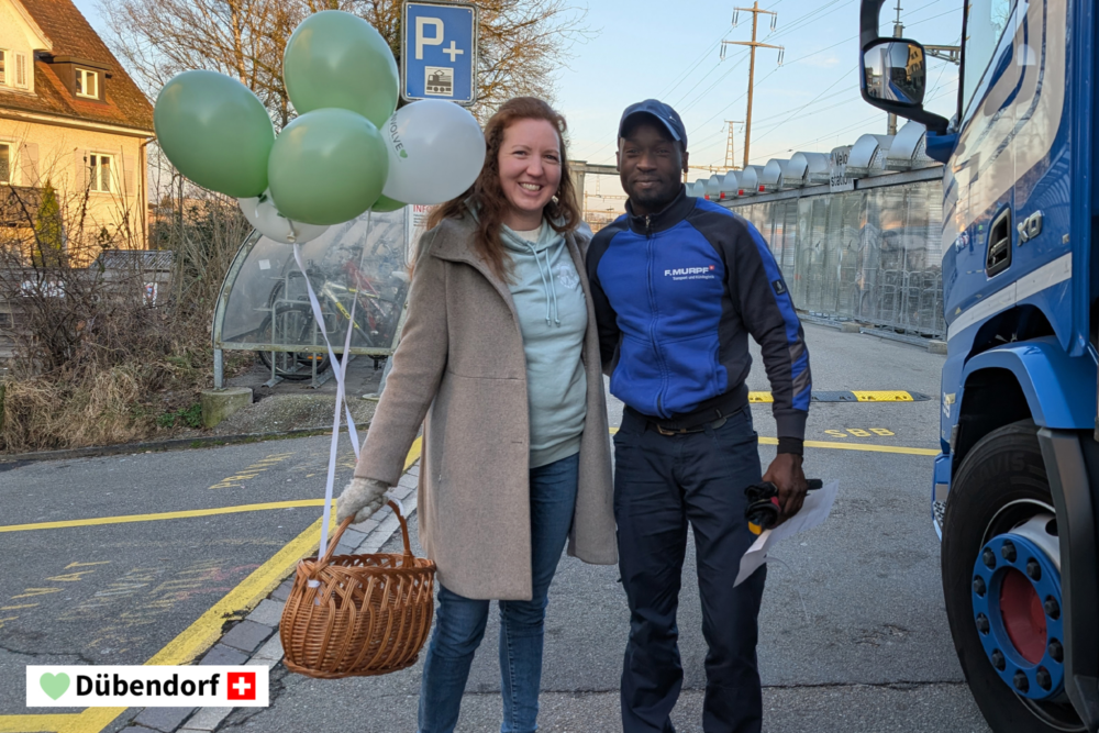 Heidi Niederberger, Leiterin Produktmanagement, mit einem Passanten in Dübendorf. Sie stehen beisammen und lachen freundlich in die Kamera.