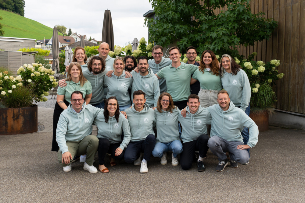 Teamfoto der Involve AG bei der Sommertagung 2025; Viele der Mitarbeitenden tragen mintgrüne Hoodies