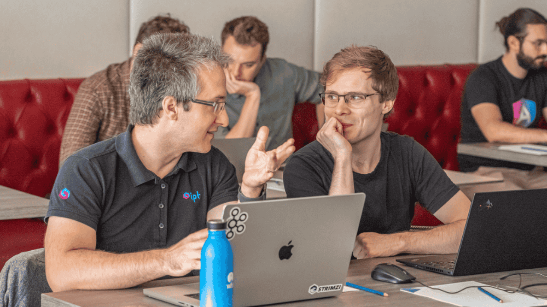 Patrick Nick von ipt, IT-Experte für LCM bei Versicherungen, erklärt einem Mitarbeiter etwas.