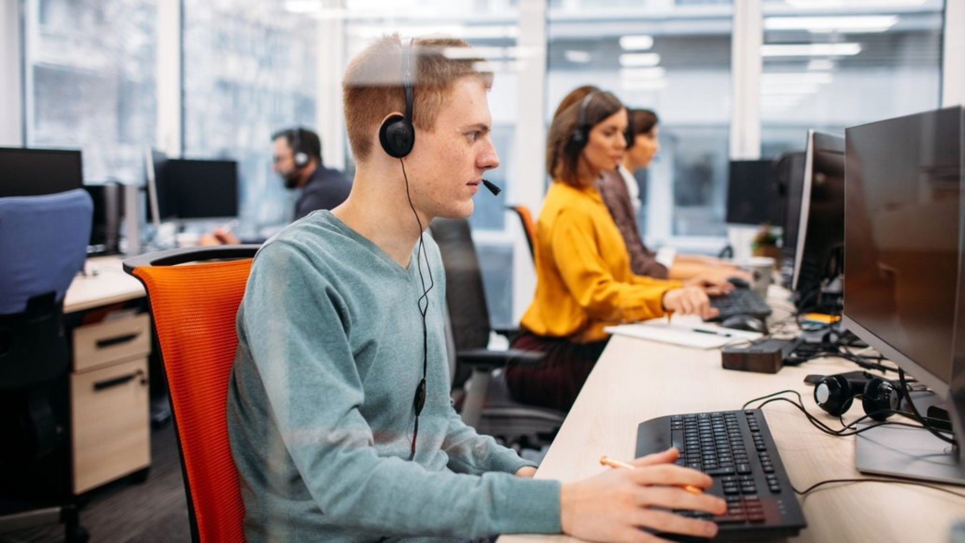 Mehrere Mitarbeiter:innen des Kundendienstes sind am Arbeiten.