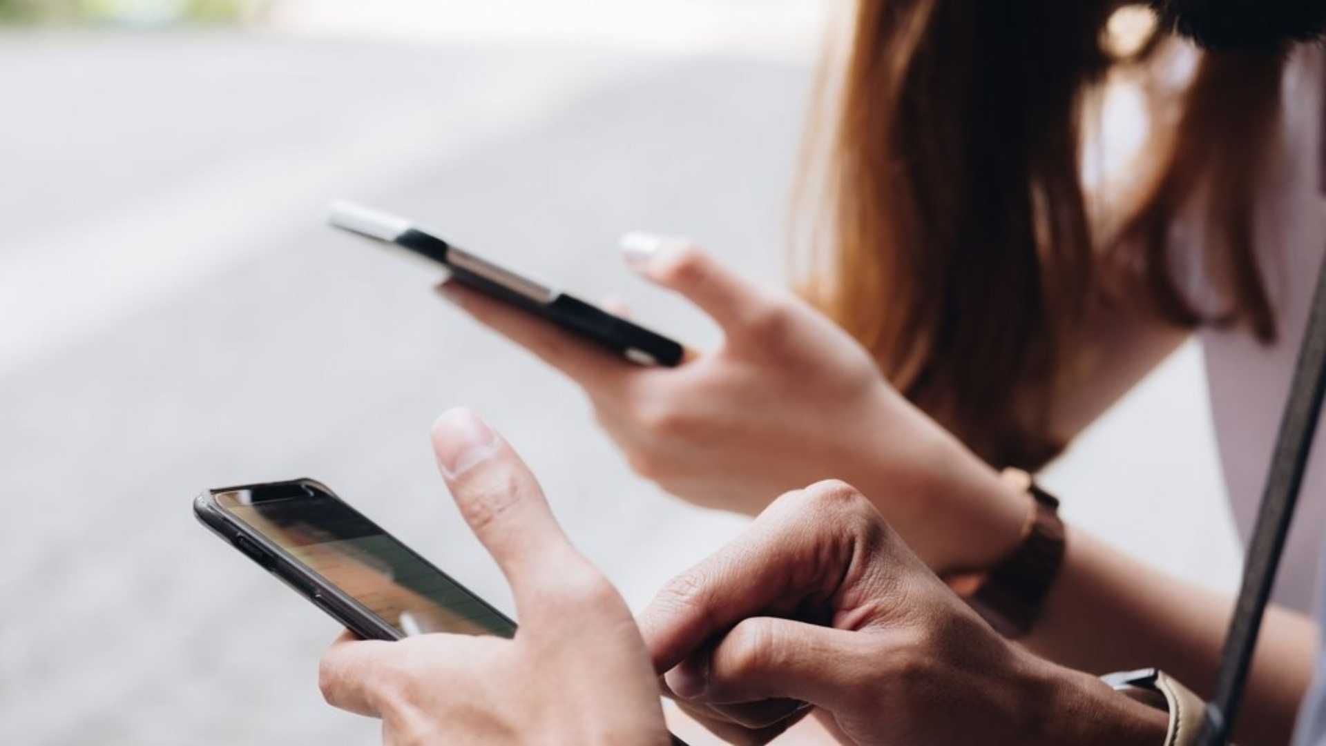Zwei Personen, die auf ihrem Handy herumklicken.