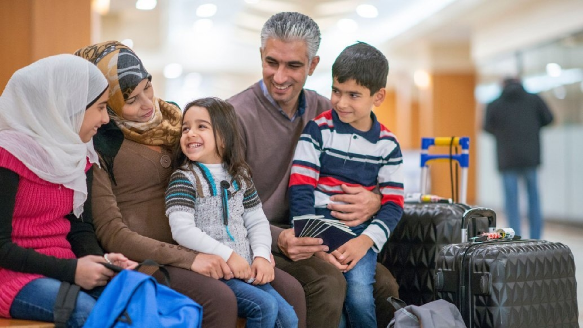 Familie mit drei Kindern, die alle beisammen sitzen.