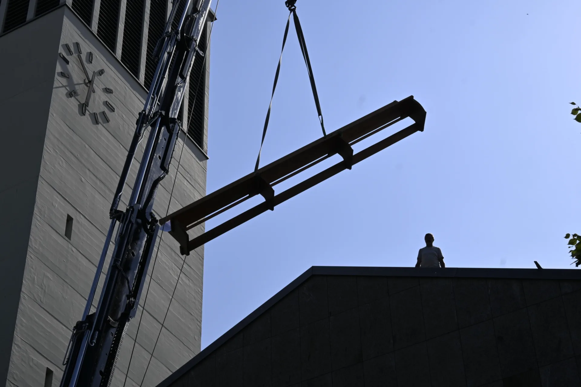Kirchenbank an Seil schwebt neben Kirchturm