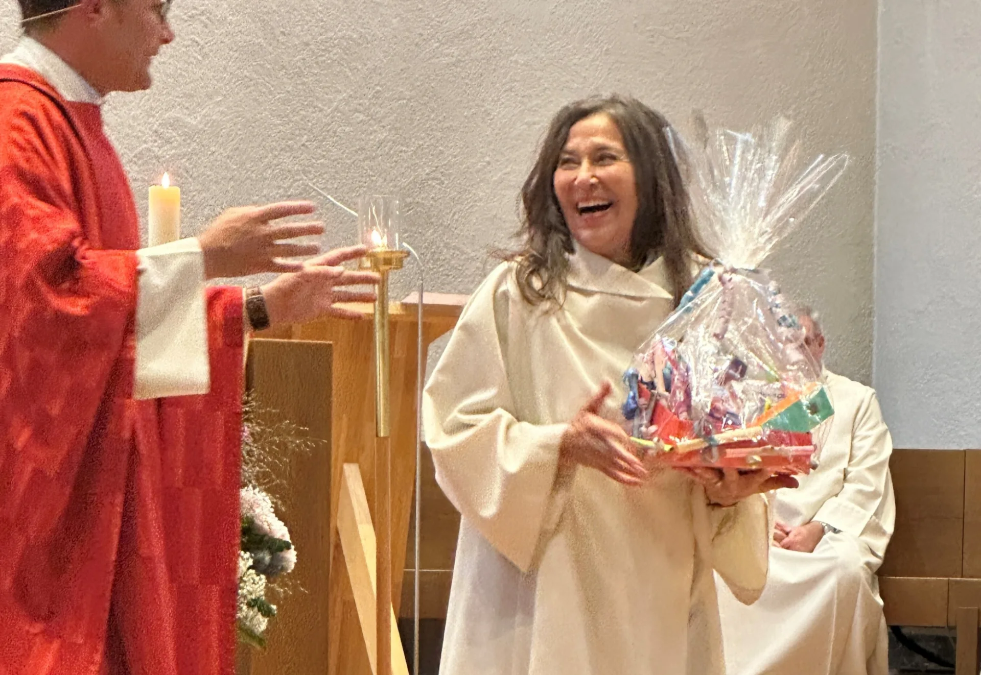 Pfarrer Kurt Schaller übergibt ein Geschenk an Karen Curjel.