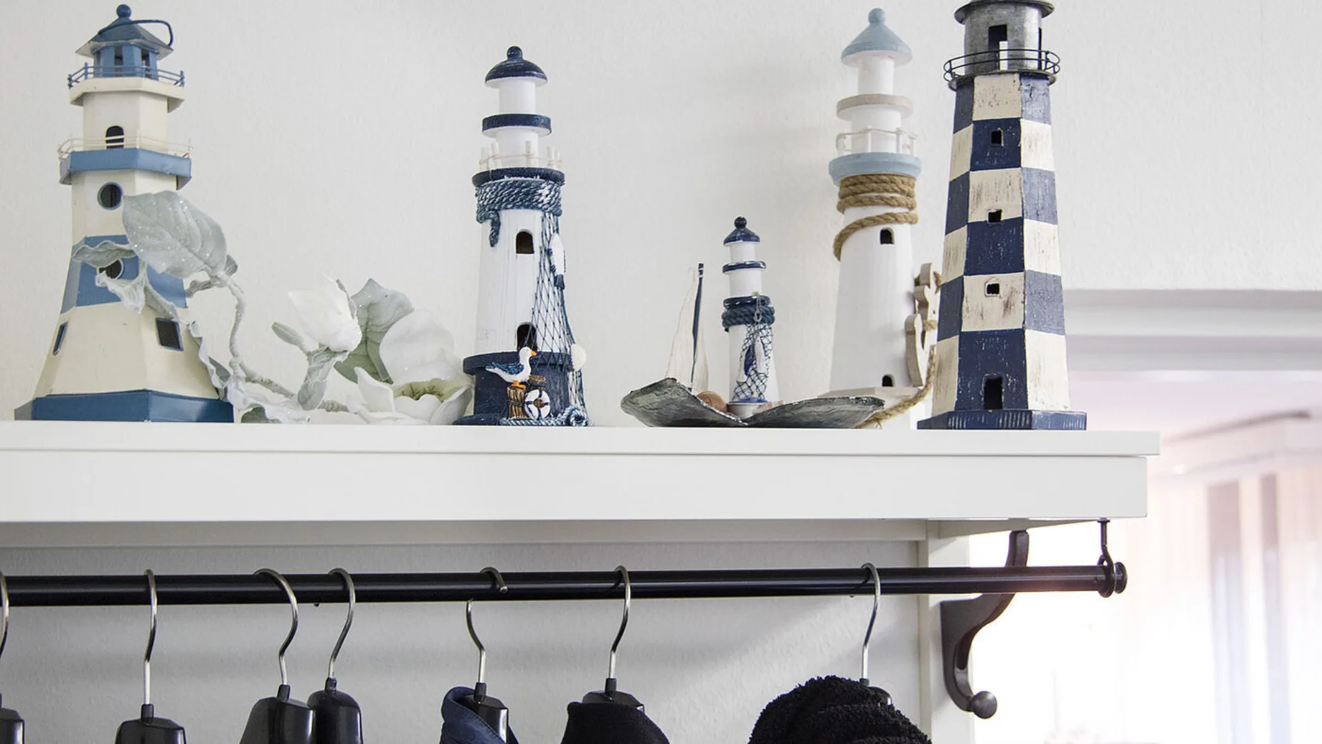 Grosse und kleine Leuchttürme aus Keramik auf einem Tablar