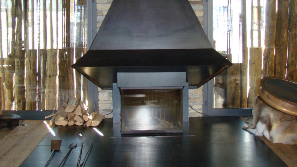 Cheminée aus rohem Stahl mit sichtbarer Hutte.