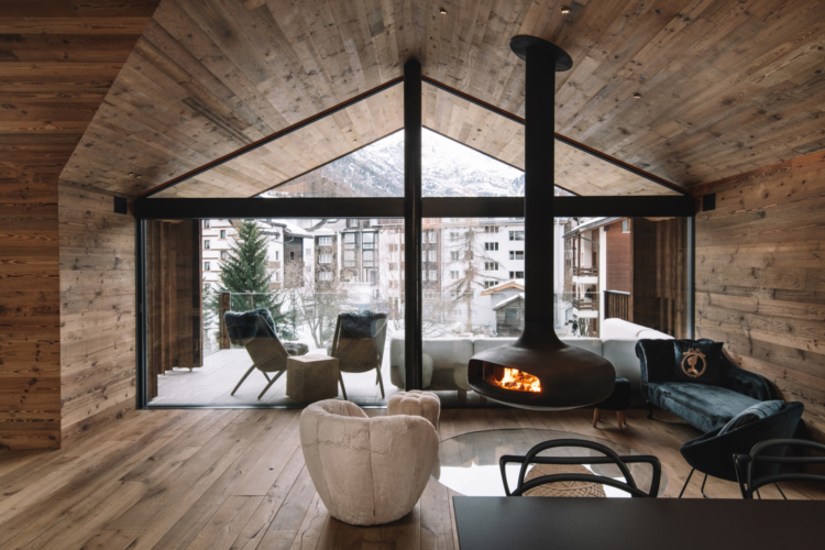 Freihängender Kaminofen Domofocus vitré zentral platziert im Wohnbereich eines Chalets
