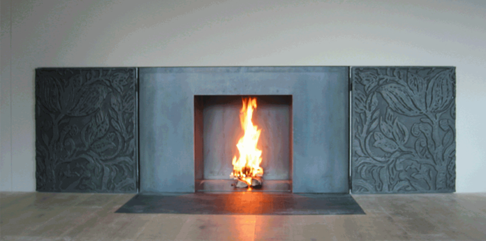 1-seitiges, bodenebenes Cheminée aus rohem Stahl.
Im Wohnbereich in die Wand eingebaut.