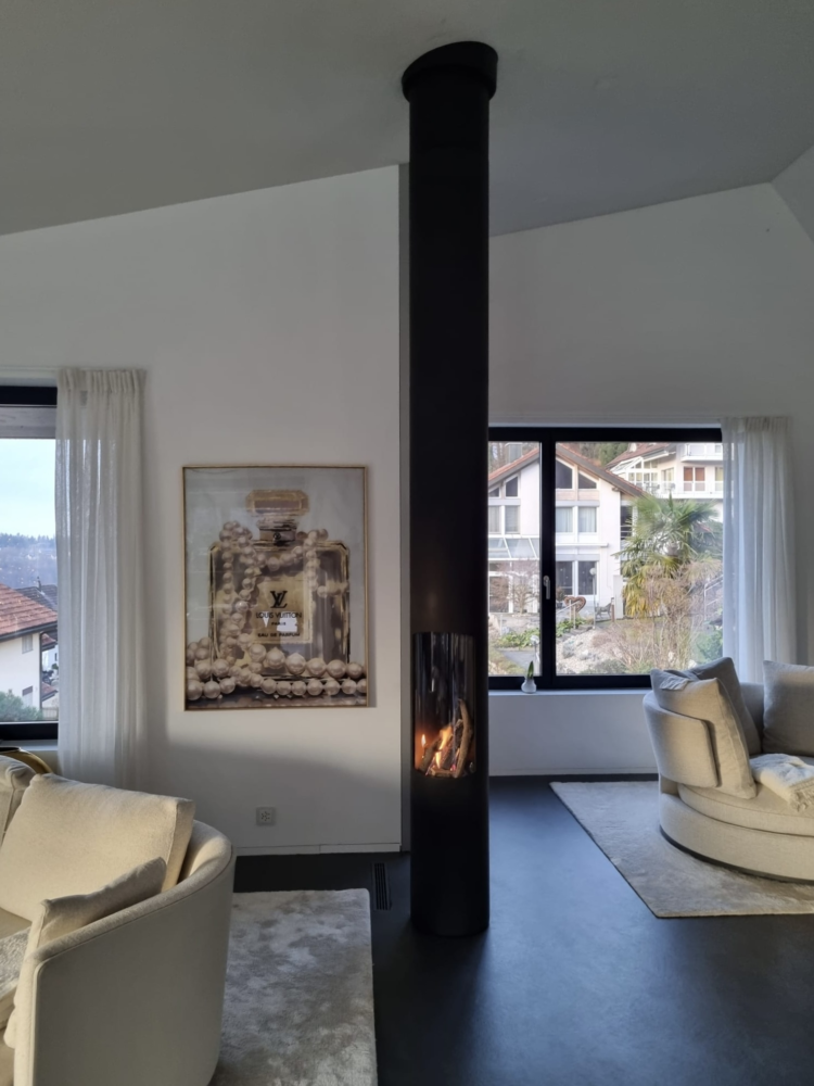 Freihängender Kaminofen Slimfocus mit Fuss. Er beansprucht extrem wenig Platz und kann zentral, an der Wand oder als Eckmodell installiert werden.