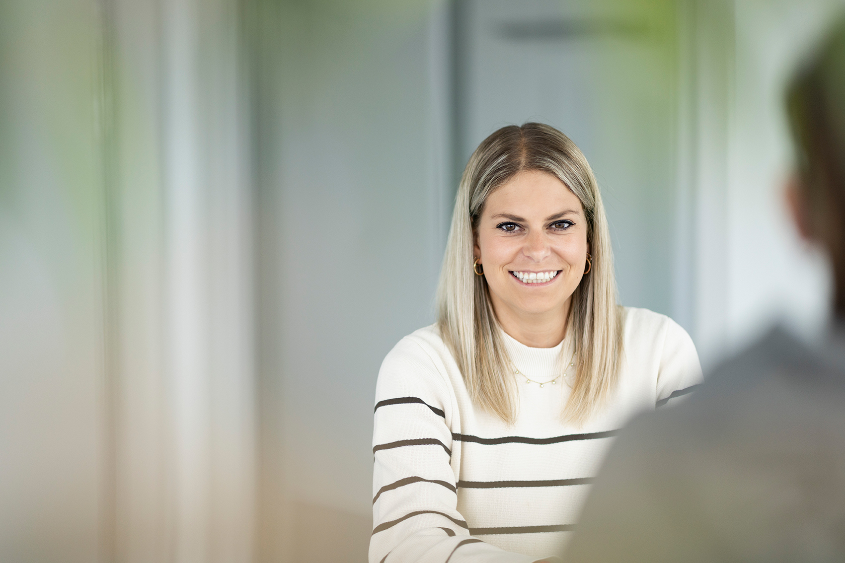 junge blonde Fachexpertin der ZVB im Büro die sich freut zu beraten