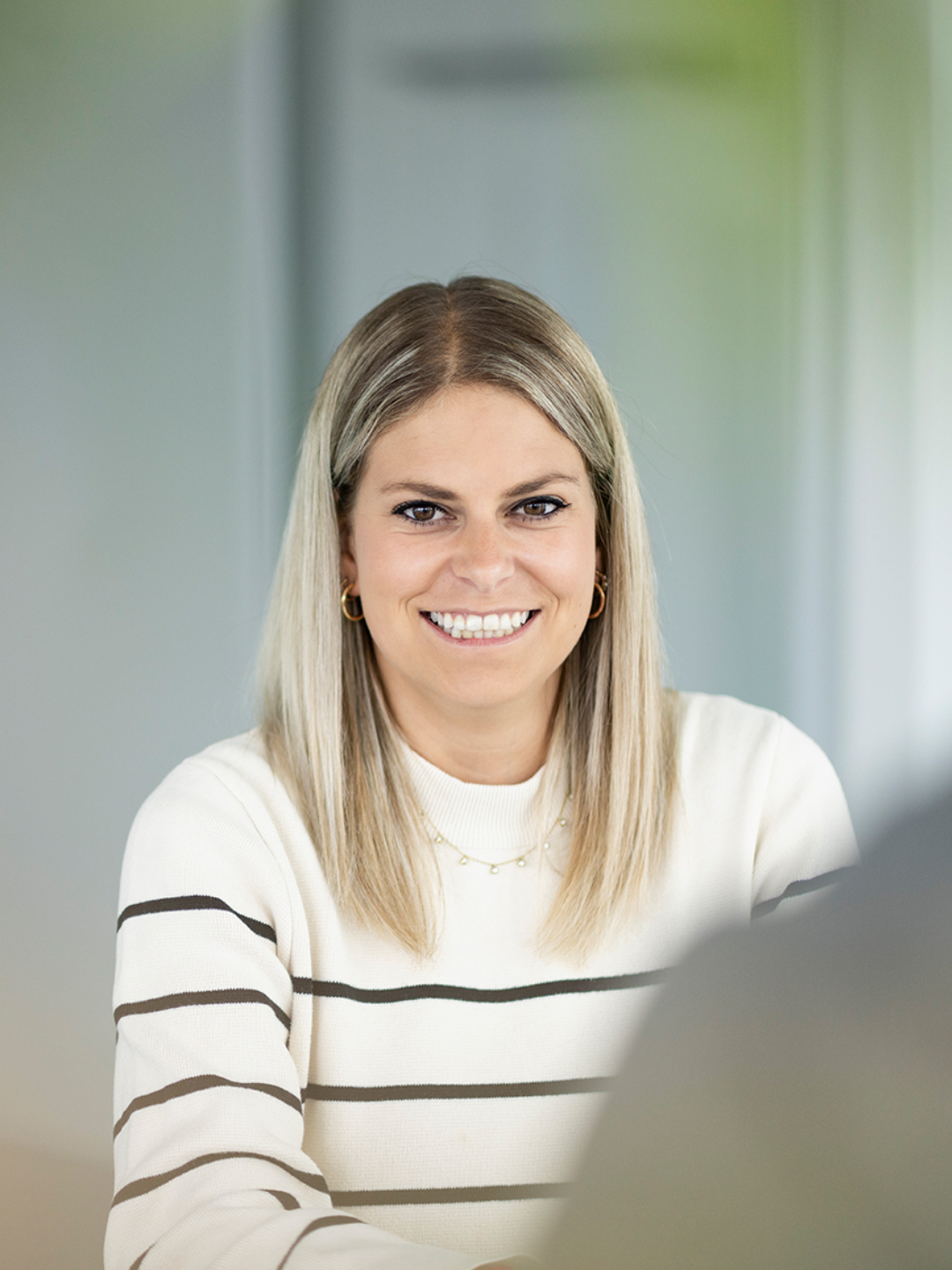 junge blonde Fachexpertin der ZVB im Büro die sich freut zu beraten
